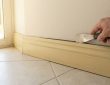 Technician tightening loose exterior skirting panel
