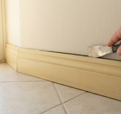 Technician tightening loose exterior skirting panel